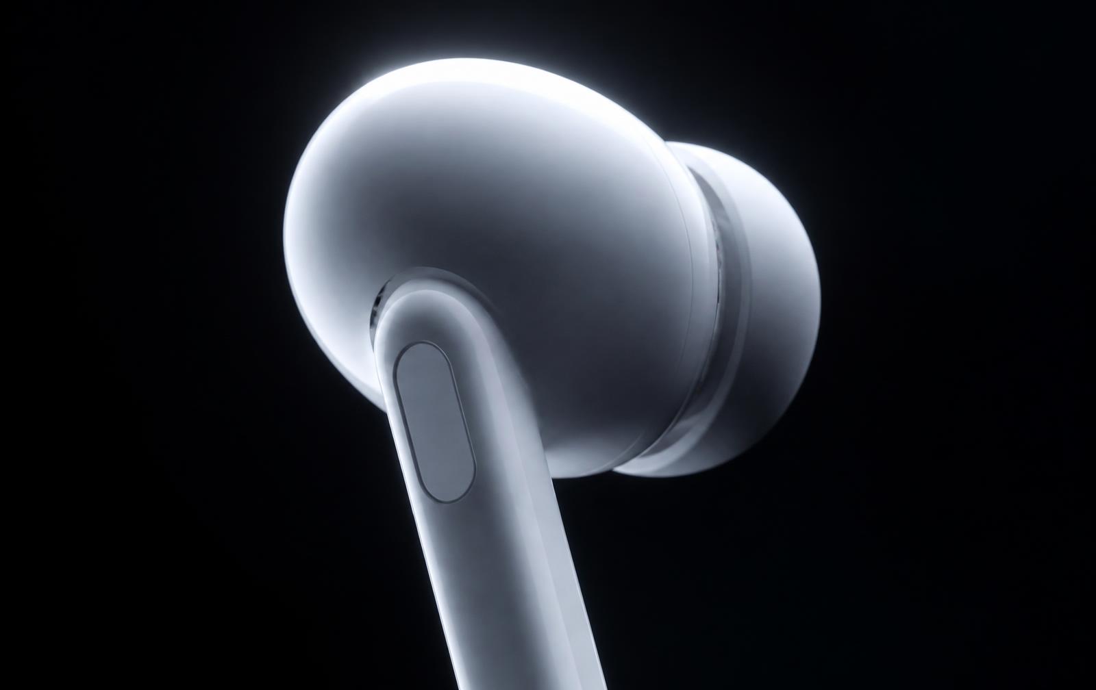 Close-up of an AirPods Pro earbud lit against a black background